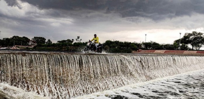 Dramatic stormy-sky photo of a motorcyclist crossing a dam, part of Pragati's personal photography