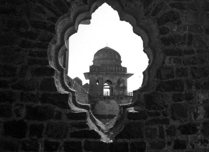 Monochrome photo of a domed structure framed through a jharokha archway, part of Pragati's personal photography