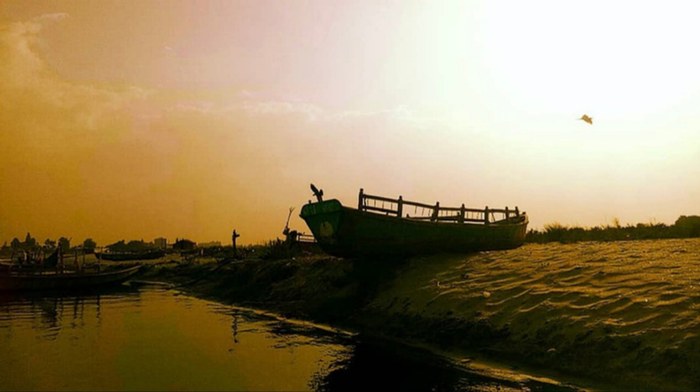 Warm duotone sunset photo of a boat by the water, part of Pragati's personal photography